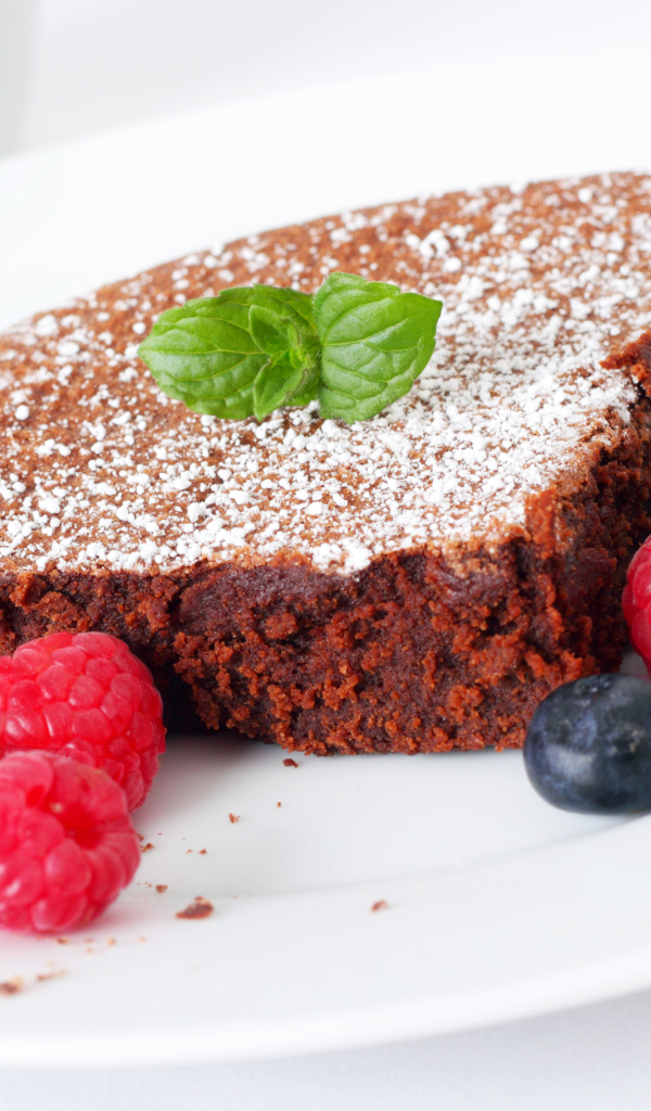 Шоколадный десерт брауни с ягодами малины и черники