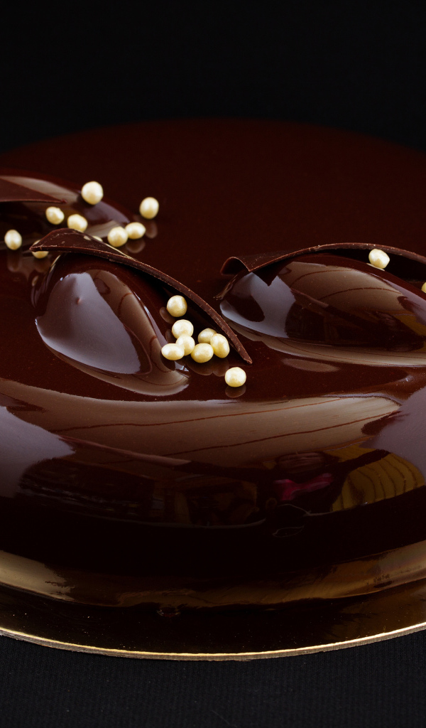 Шоколадный глянцевый торт на черном фоне 