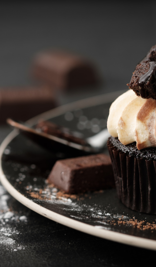 Шоколадный маффин с кремом на тарелке 