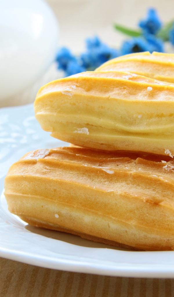 Заварные пирожные на большой белой тарелке 