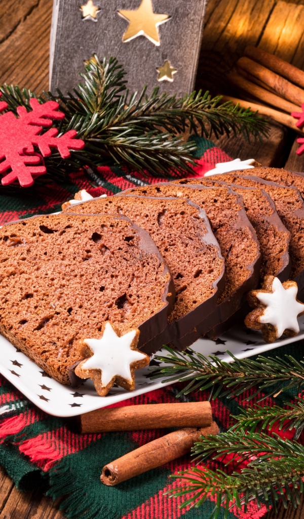 Рождественский кекс на столе с еловыми ветками и корицей