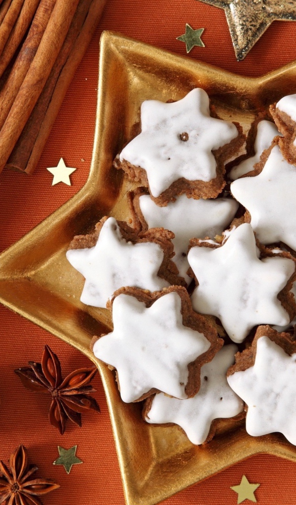 Печенье с глазурью на столе с орехами, корицей и бадьяном