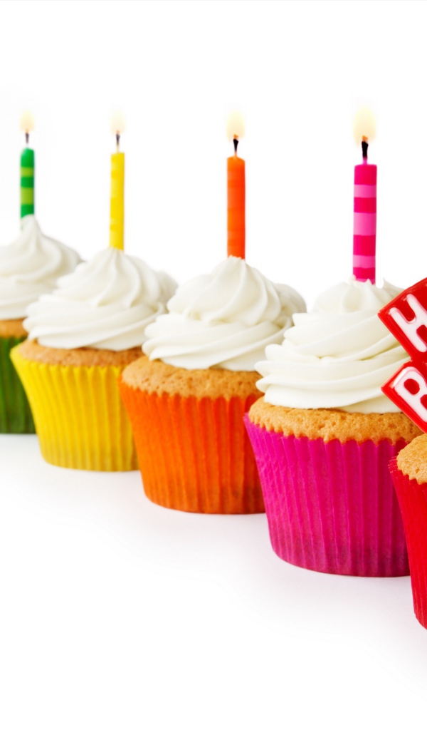 Кексы со свечами и кремом на день рождения на белом фоне 