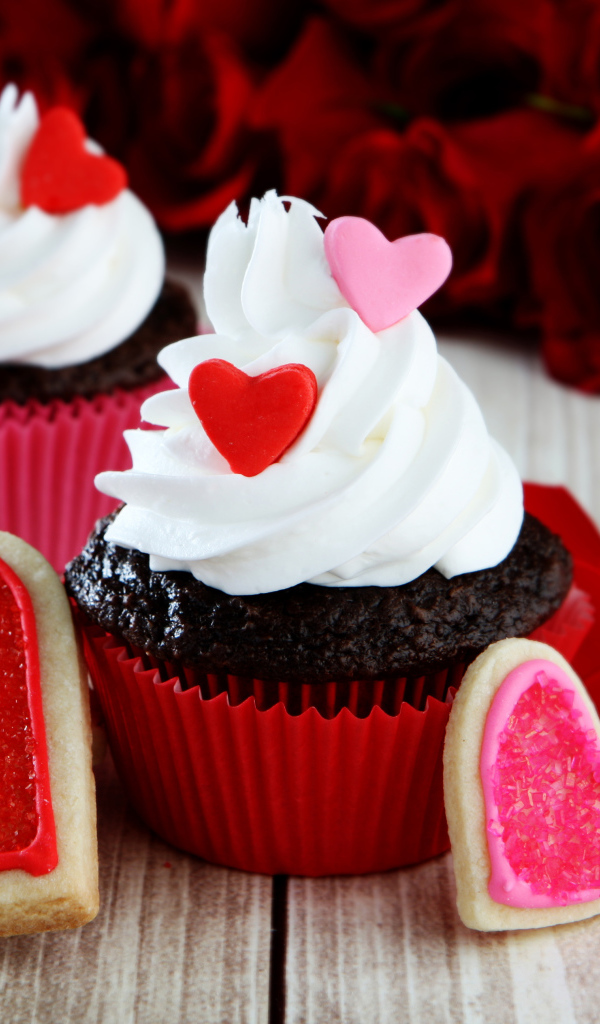 Капкейки с кремом и печенье в форме сердечек на столе