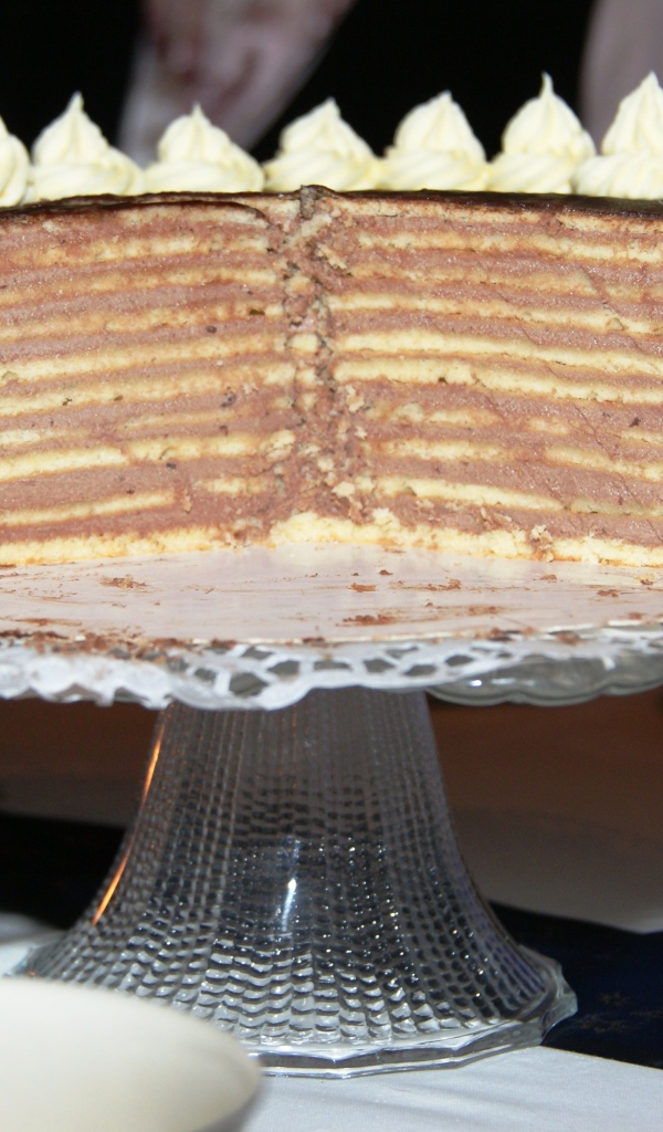 Разрезанный торт с кремом на стеклянном блюде