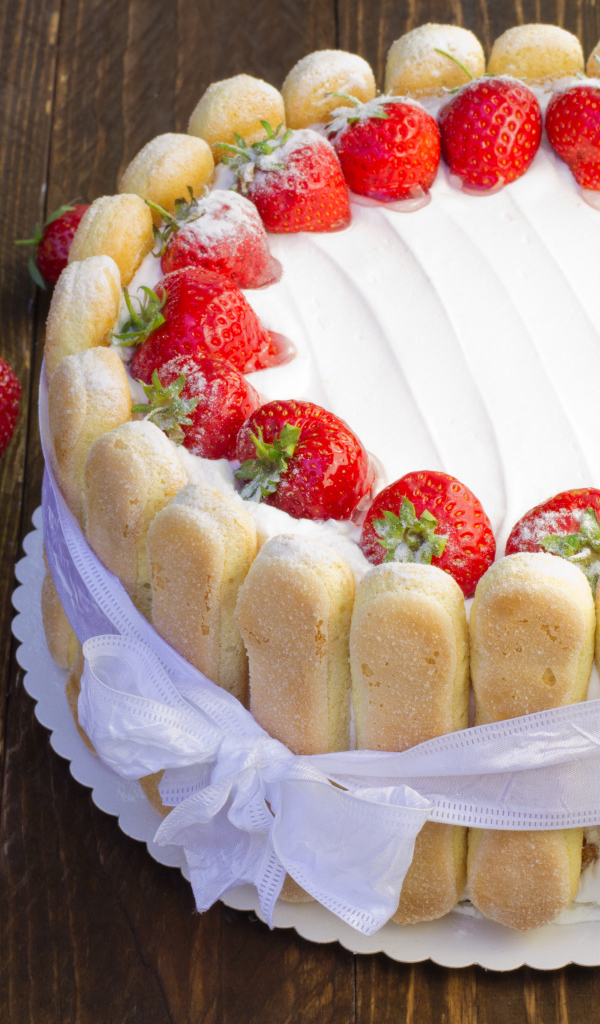 Вкусный торт с клубникой и печеньем перевязан бантом