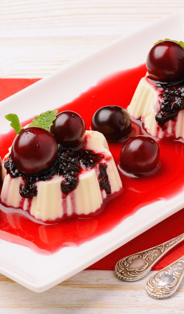 Десерт с желе и ягодами черешни на тарелке с сиропом