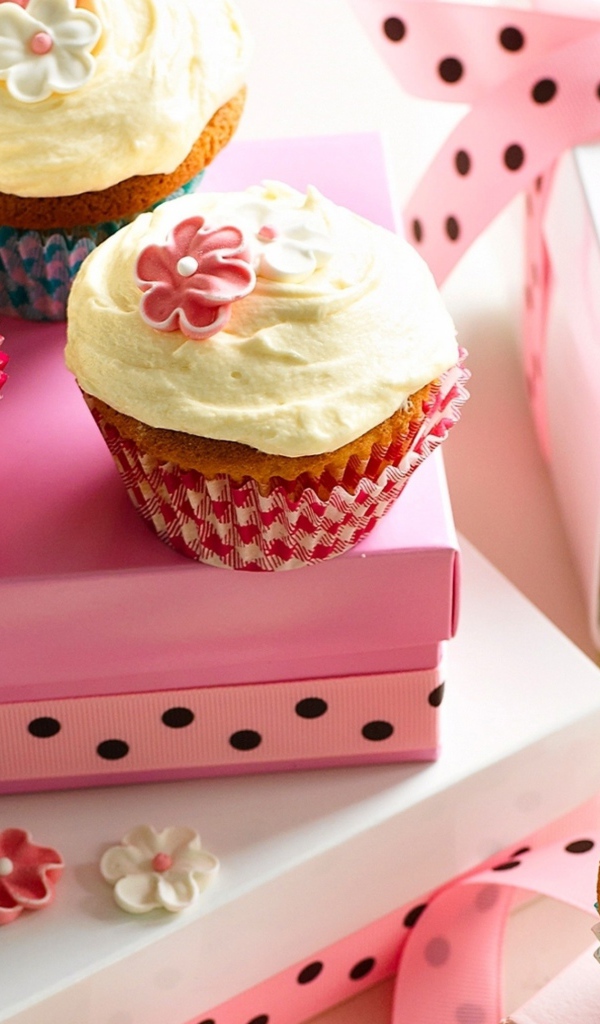 Праздничные кексы с кремом и подарочной коробкой на столе