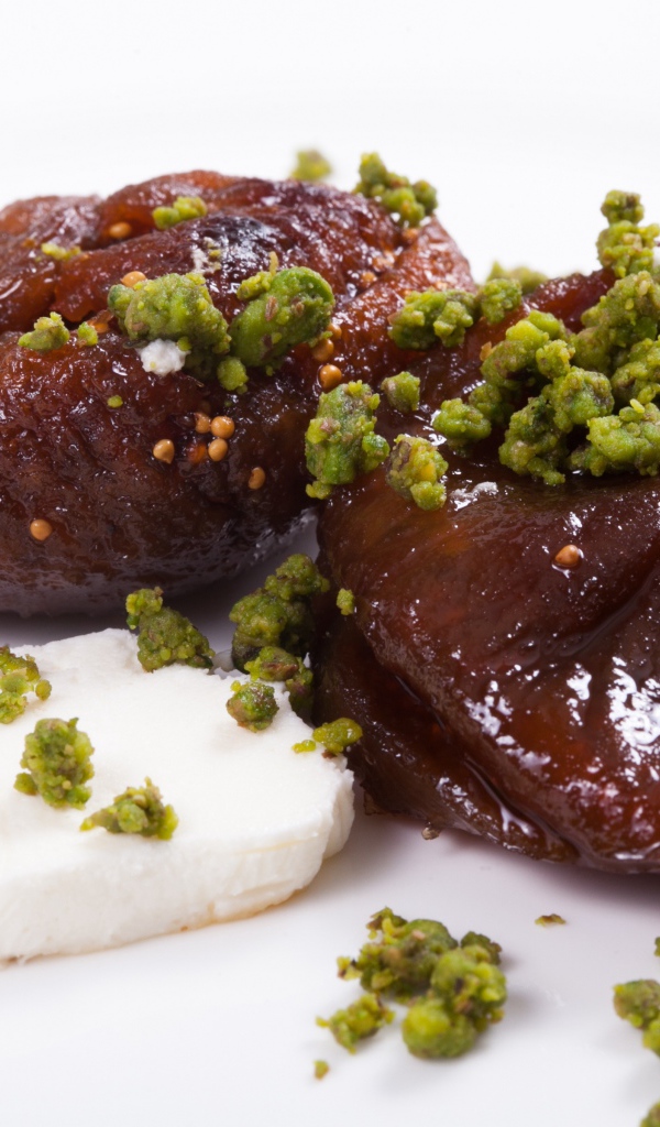 Инжир с фисташковыми орехами на белом фоне