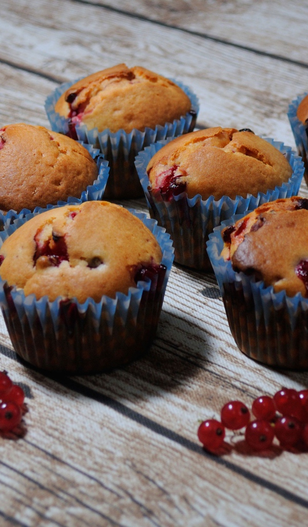 Свежие кексы с красной смородиной на деревянном столе 