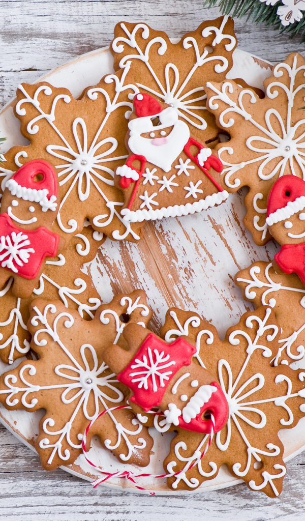 Имбирное новогоднее печенье с еловыми ветками на деревянном столе