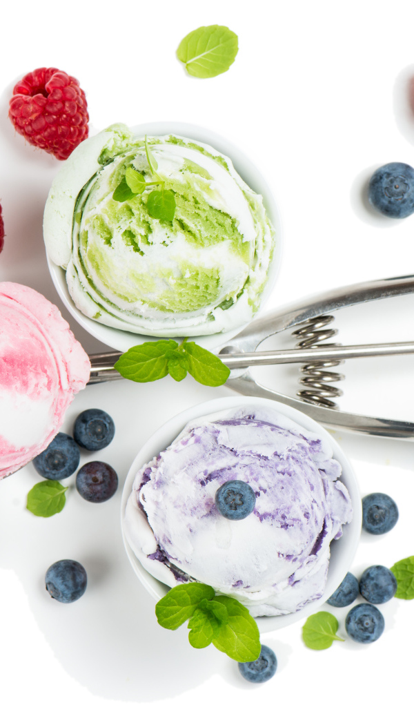 Шарики мороженого на столе с ягодами черники и малины 