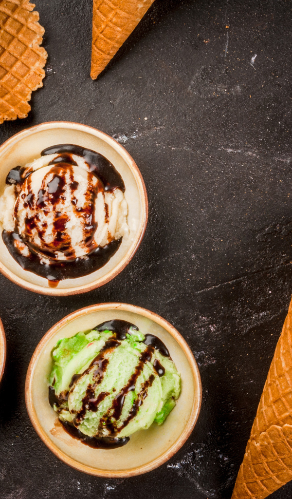 Шарики мороженого с вафельными рожками на столе 