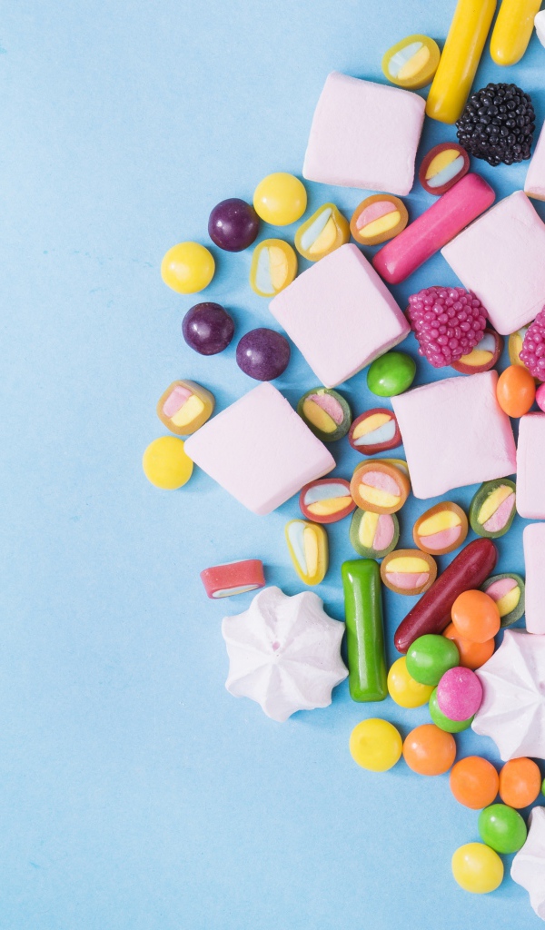 Маршмеллоу, конфеты и желе на голубом фоне