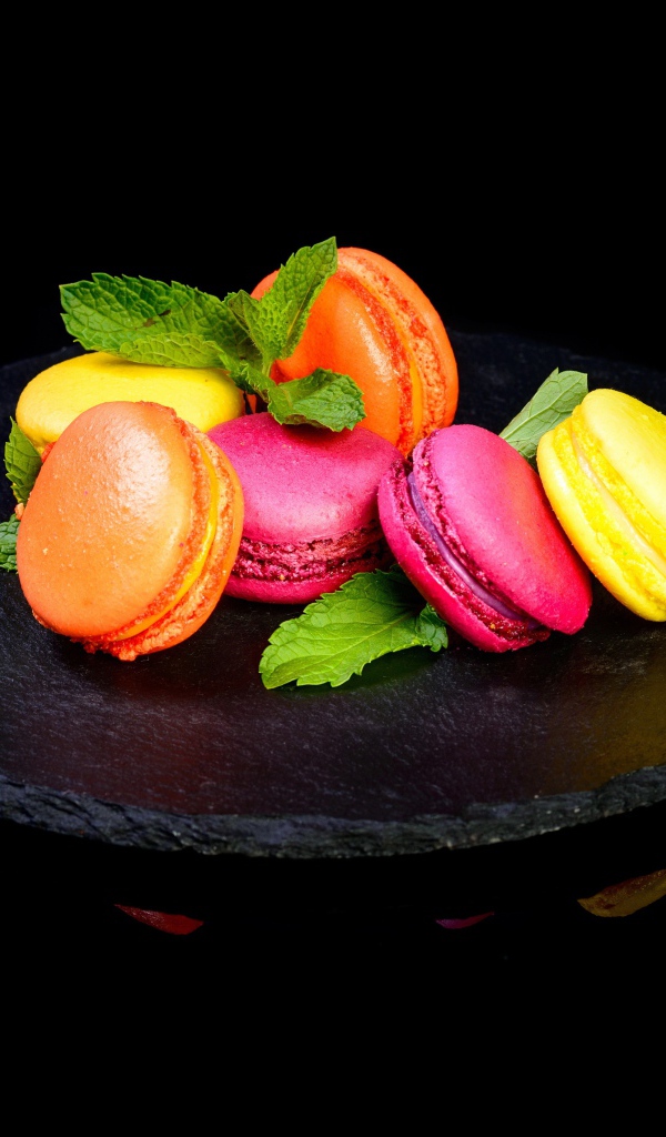 Разноцветный десерт макарон на черном фоне