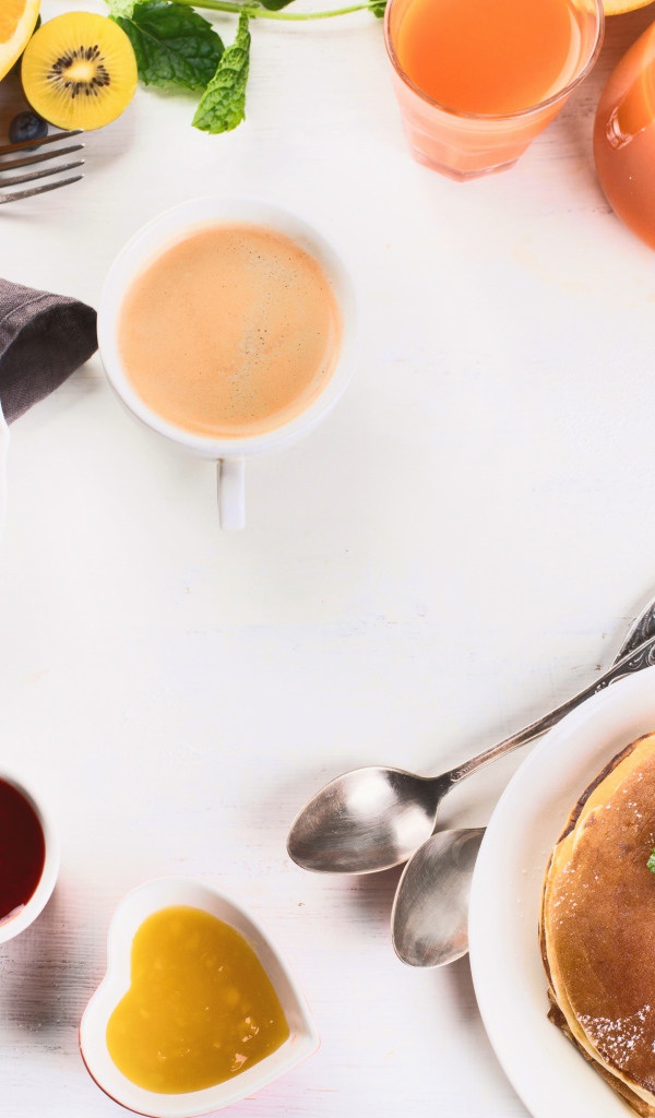 Панкейки с джемом и соком на столе на завтрак 