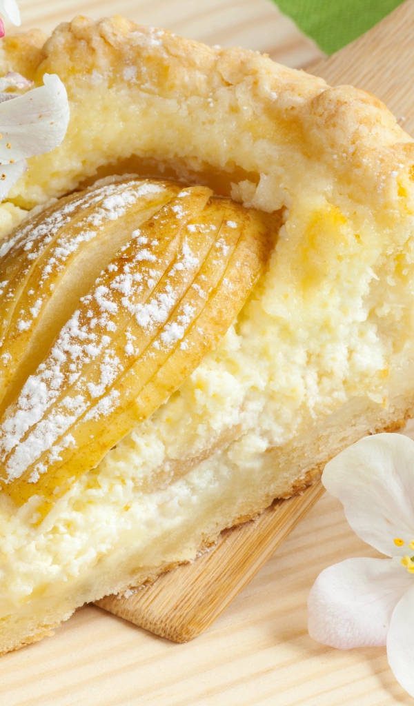 Кусок пирога с яблоками на деревянной лопатке с цветами яблони