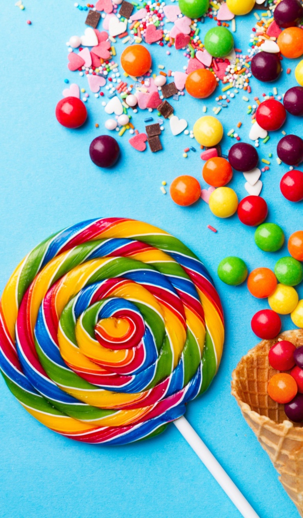 Сладкие конфеты и вафельные рожки на голубом фоне