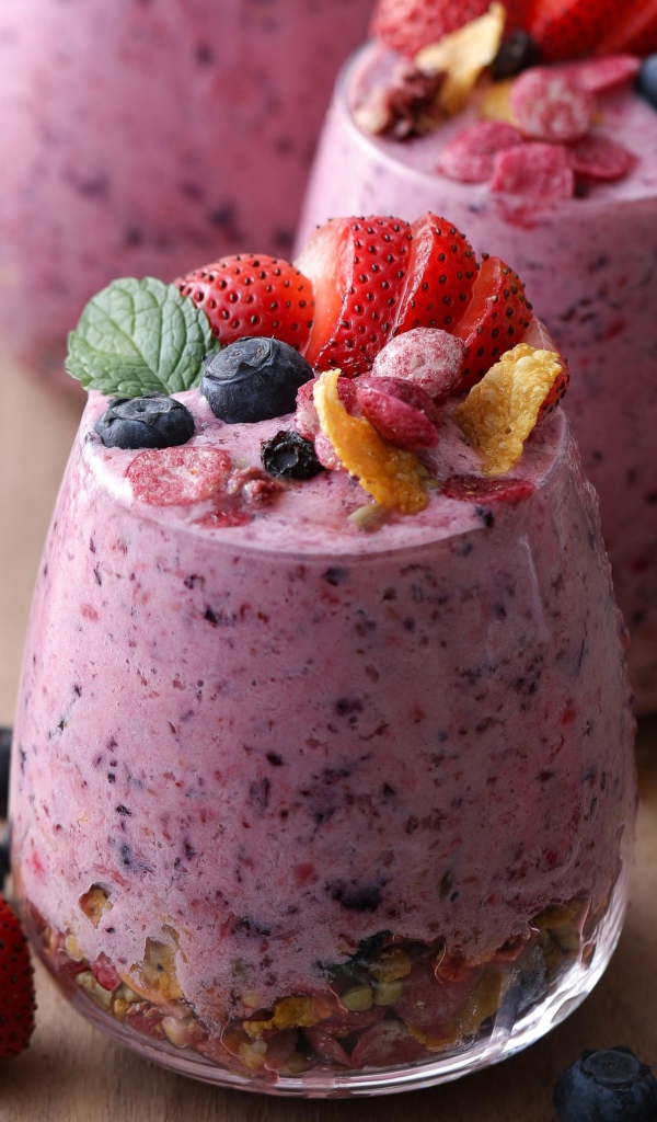 Сладкий десерт с ягодами в стаканах на столе