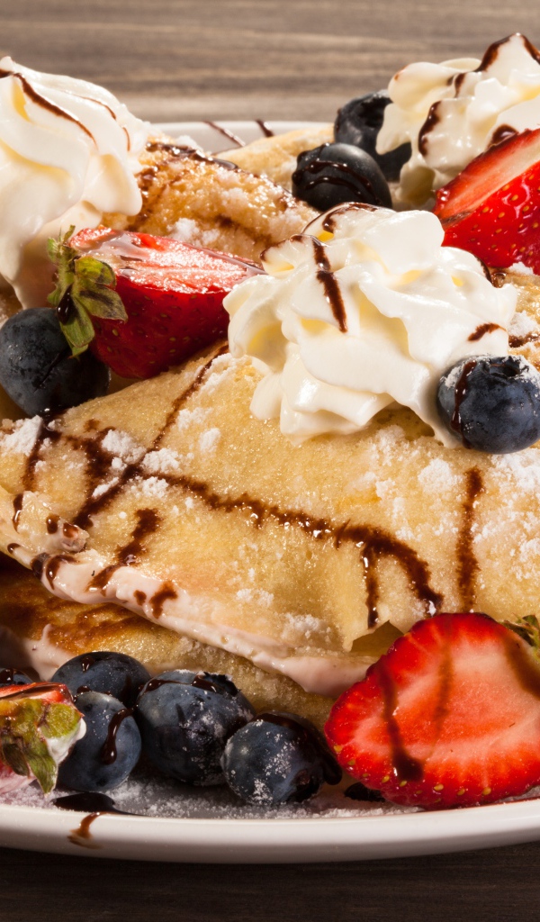 Сладкие блины с кремом, ягодами клубники и черники