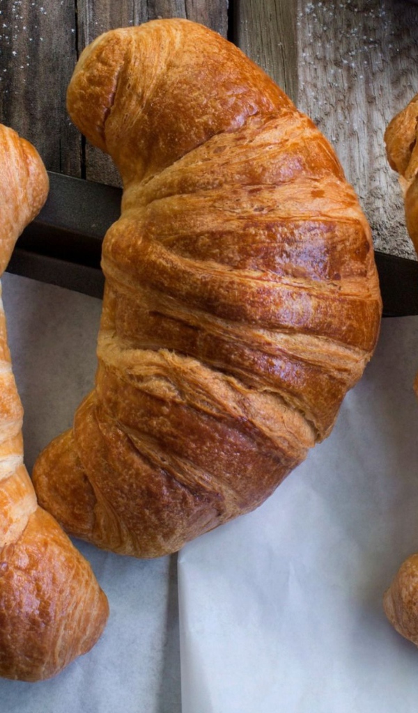 Три свежих круассана на столе с кремом 