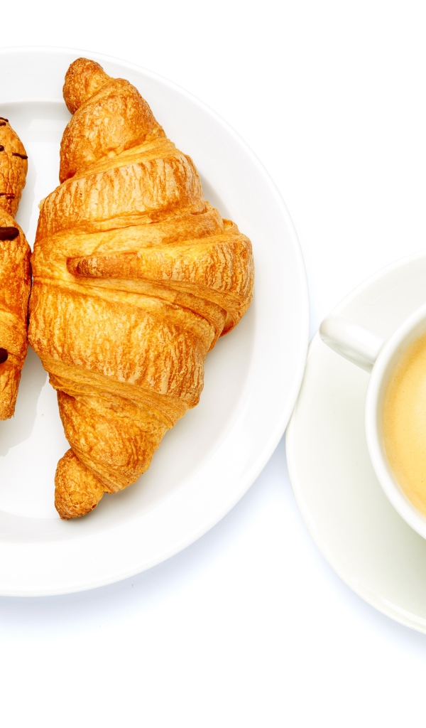 Два круассана с чашкой кофе на белом фоне