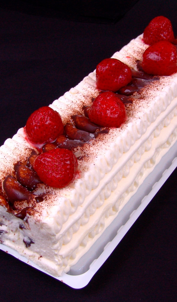 Белый торт с клубникой на черном фоне