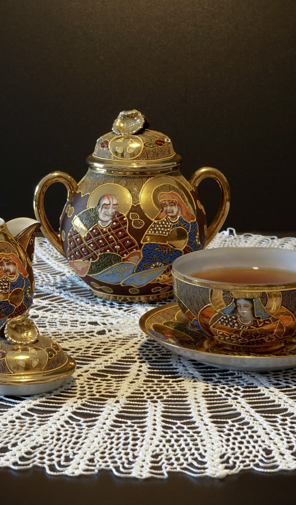 Красивый чайный сервиз на столе с белой салфеткой