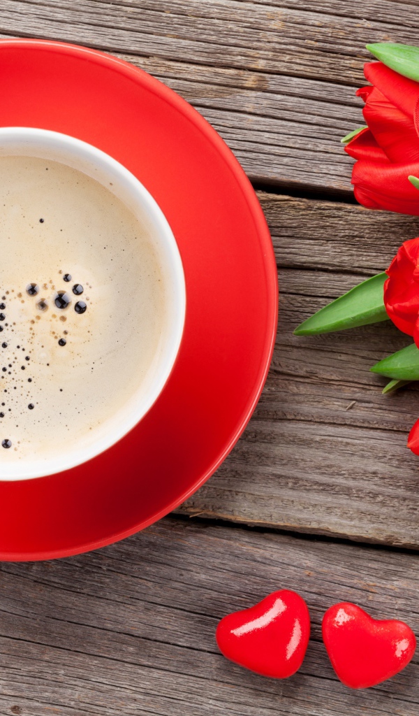 Чашка кофе с красными тюльпанами на деревянном столе 