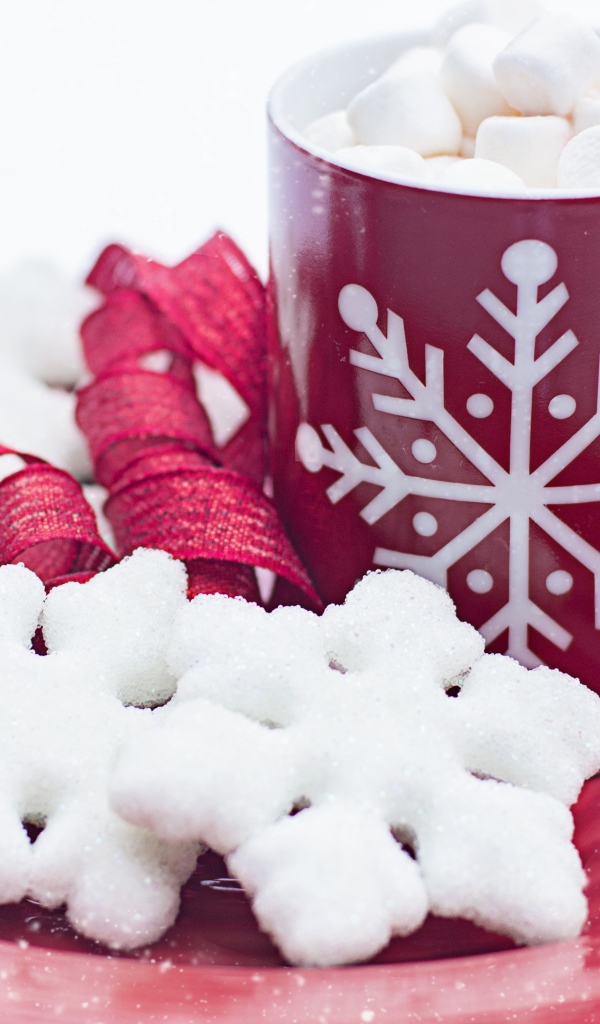 Чашка горячего шоколада с маршмеллоу на тарелке со снежинками