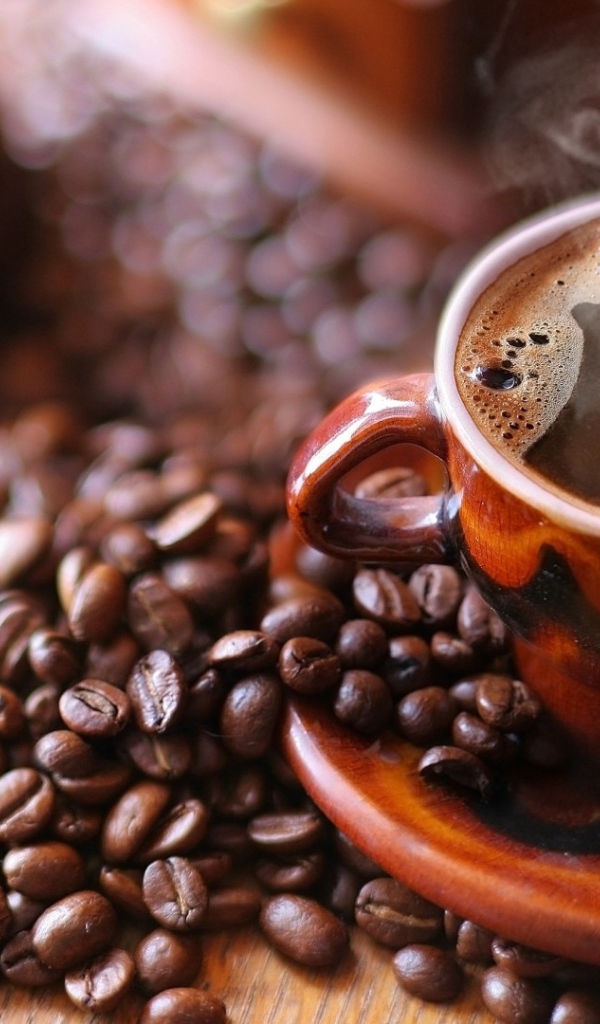 Чашка горячего кофе на столе с кофе 