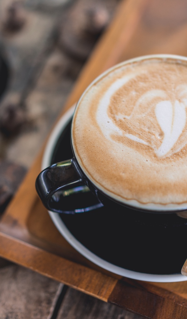 Большая чашка кофе с пеной на столе