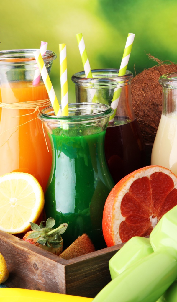 Коктейли в бутылках с трубочками на столе фруктами