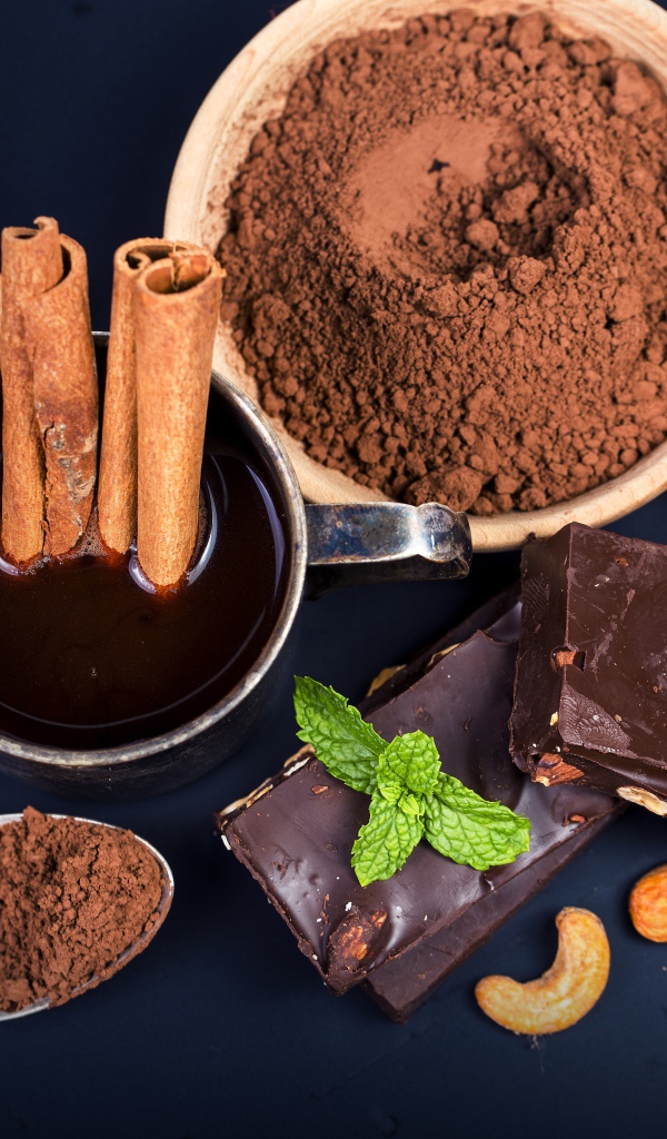 Какао с корицей, орехами и шоколадом на столе 