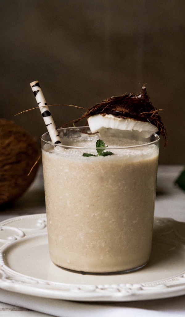 Вкусный кокосовый коктейль в стакане с трубочкой