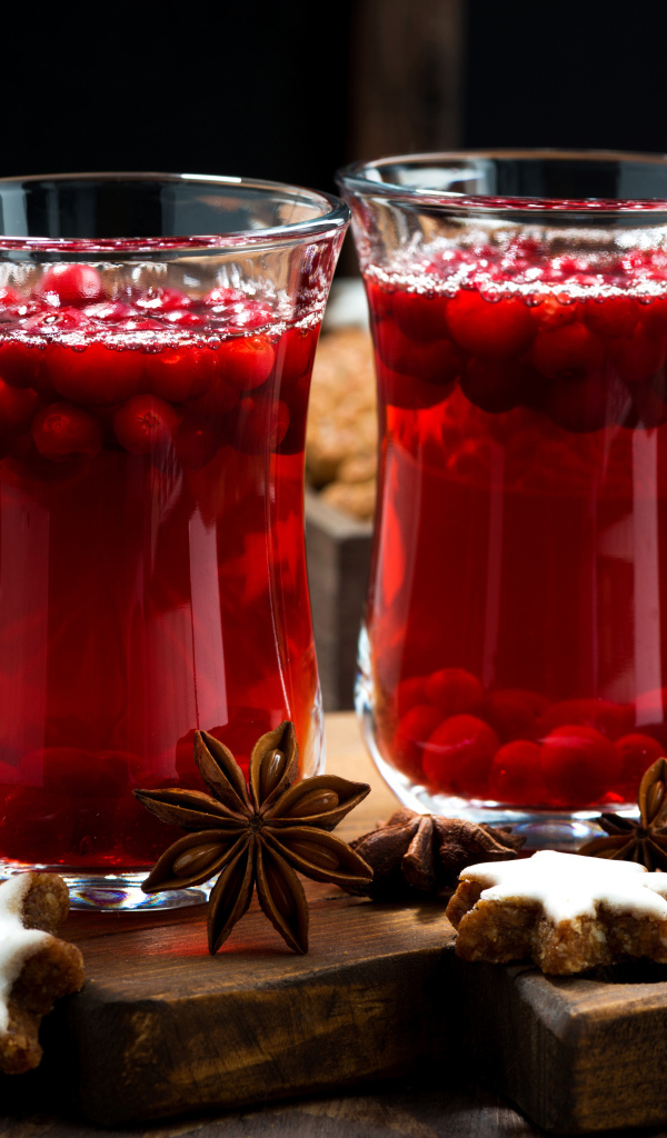 Горячий клюквенный напиток на столе с печеньем