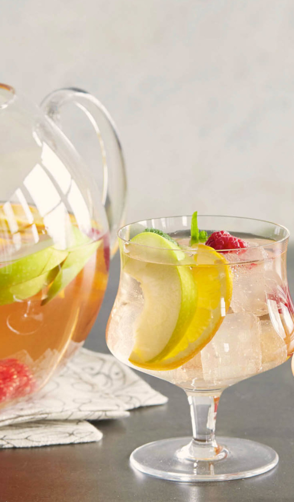 Лимонад в графине на столе с бокалами 