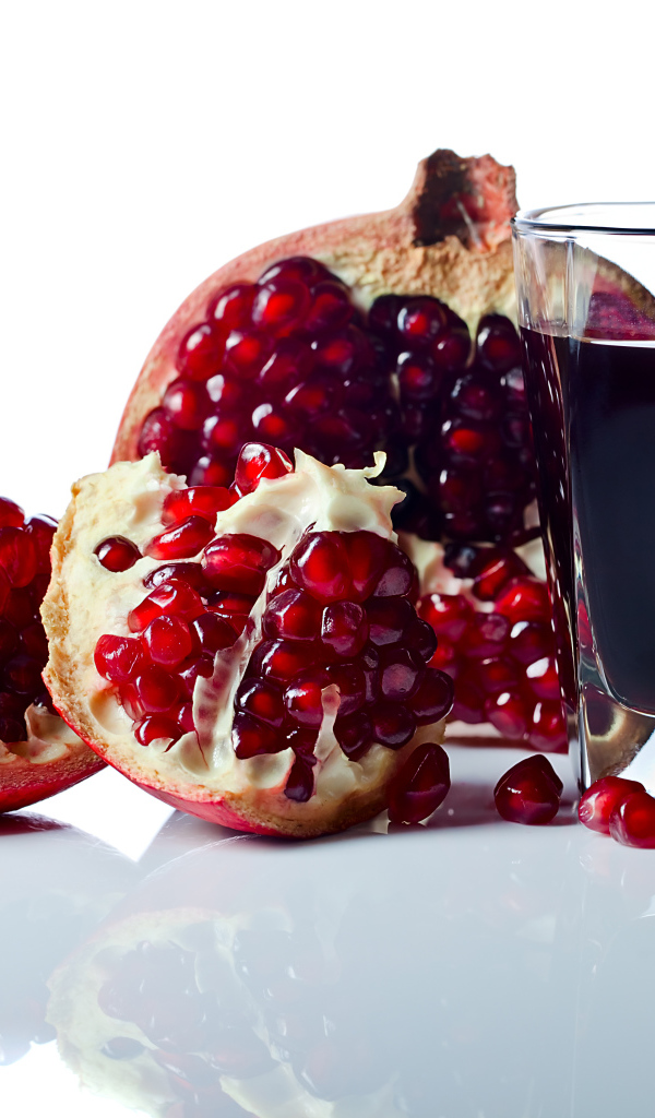 Гранатовый сок с плодом граната на белом фоне