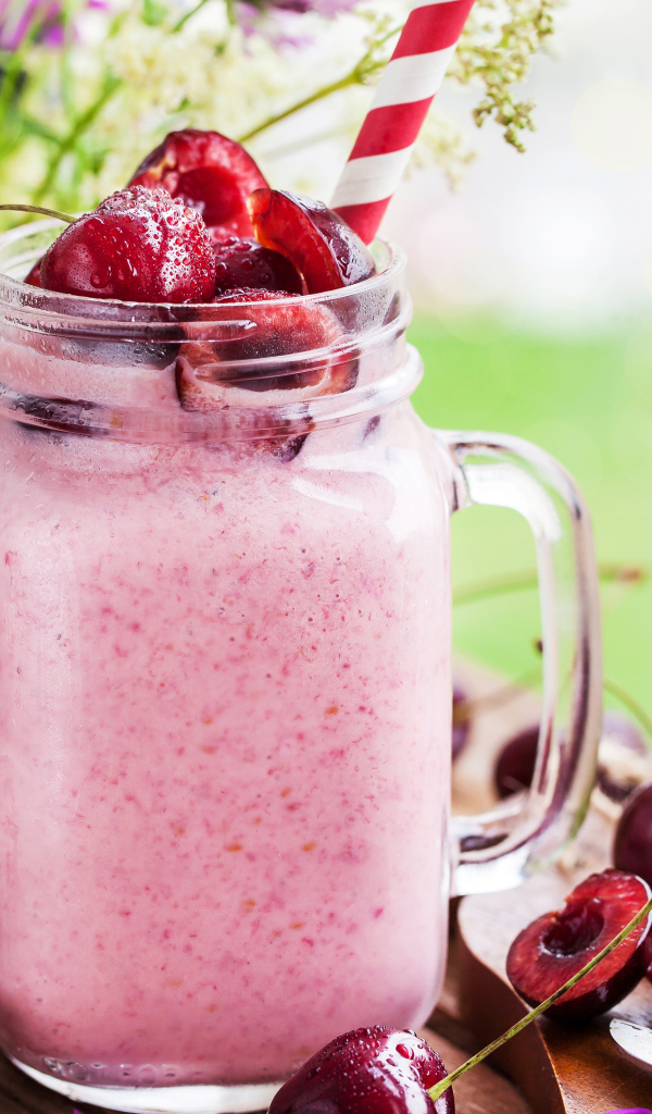 Смузи в бутылке с трубочкой и ягодами черешни 