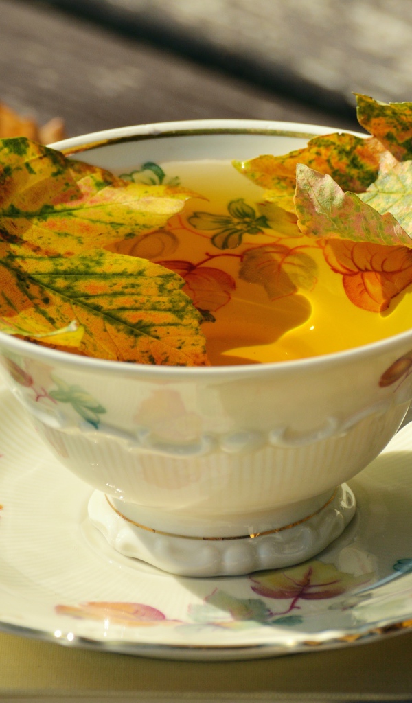 Чай в красивой чашке с осенней листвой