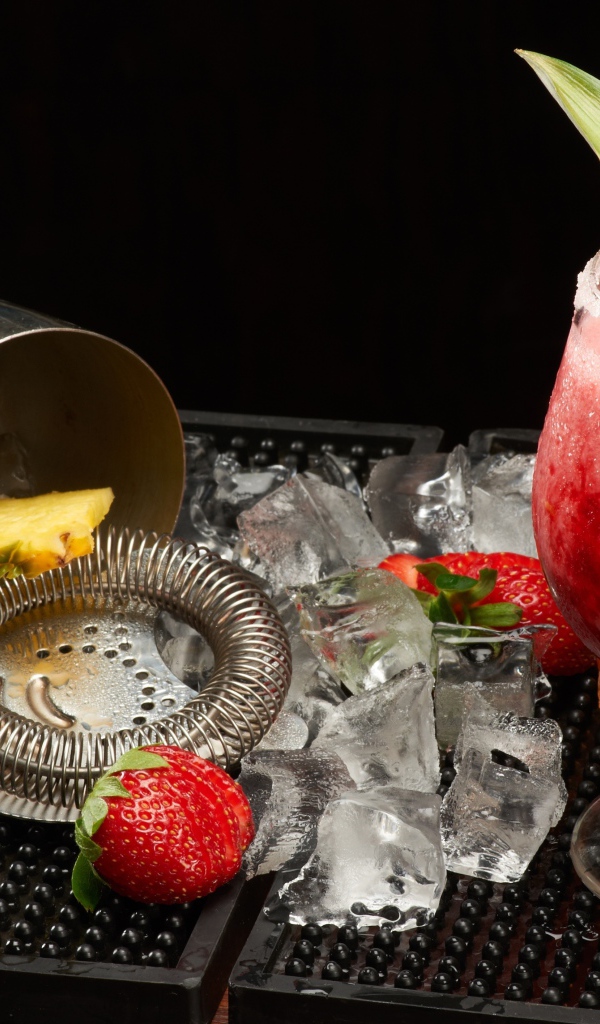 Тропический коктейль в бокале на столе со льдом