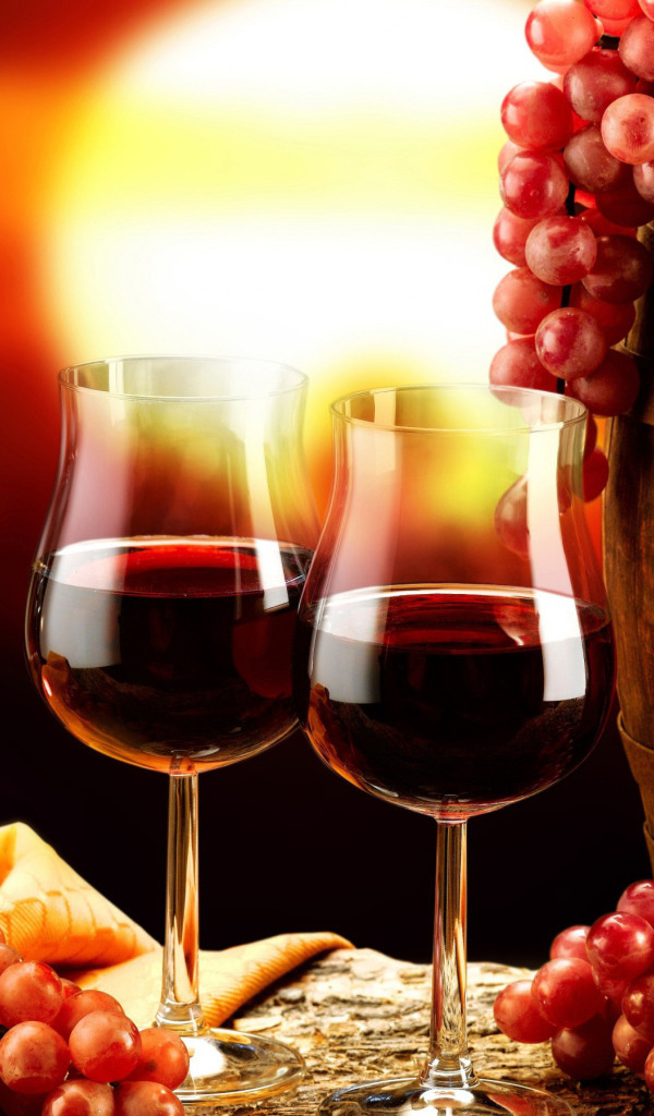 Два бокала вина на столе с бочкой и гроздьями винограда 