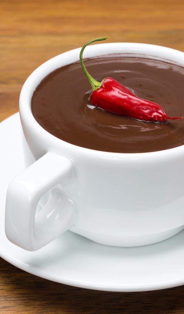 Белая чашка горячего шоколада с красным перцем