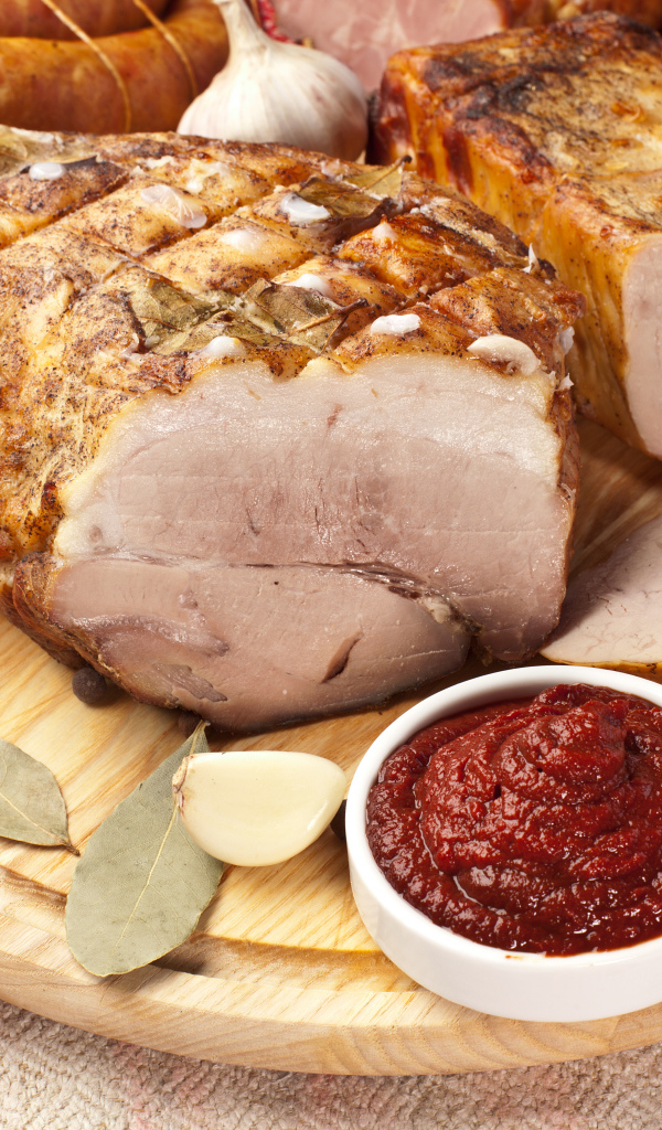 Аппетитная ветчина на столе с соусом и помидорами