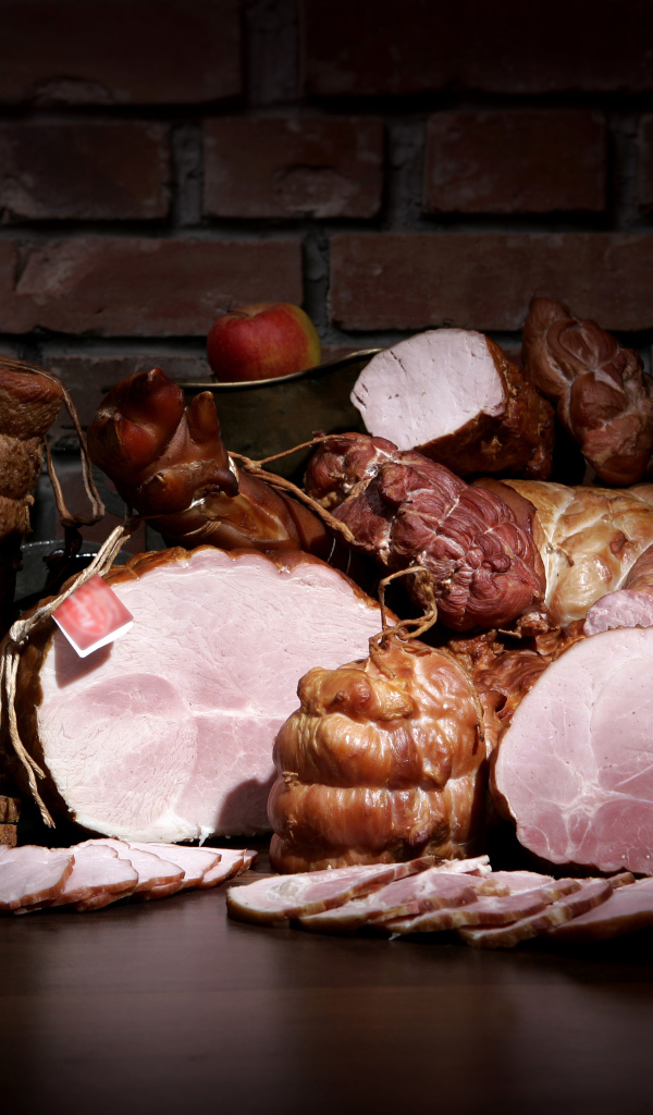 Аппетитные мясные продукты на фоне кирпичной стены 