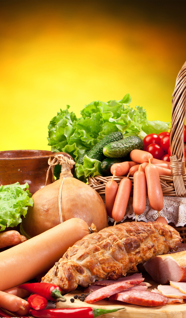 Appetizing meat products on the table with a basket of vegetables