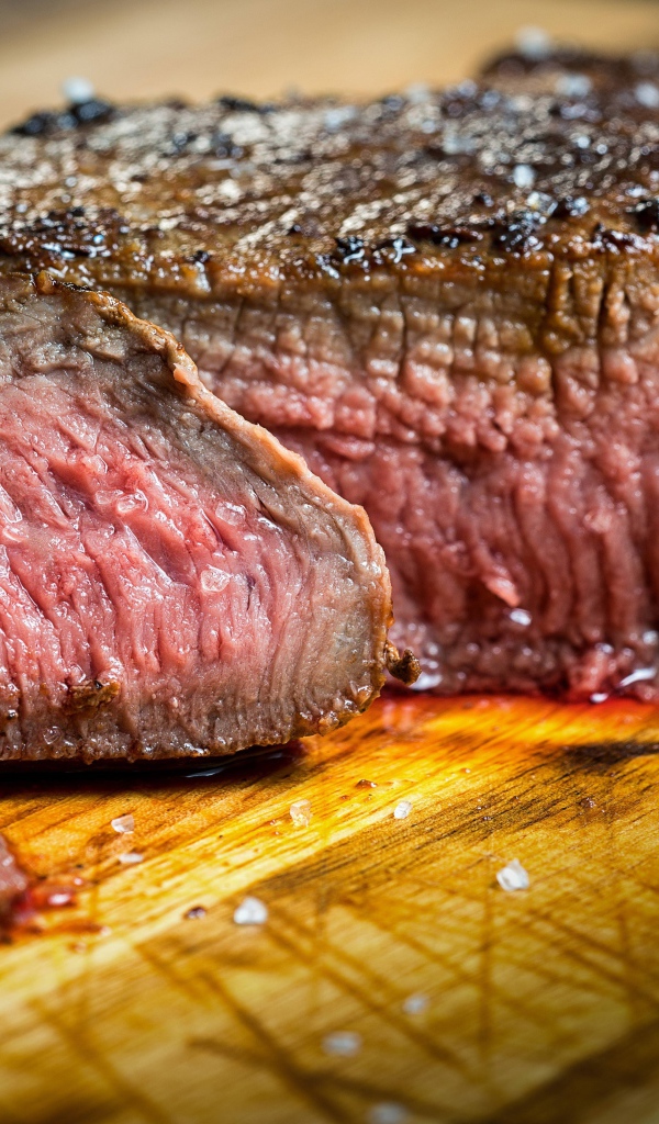 Аппетитный нарезанный кусок мяса на разделочной доске