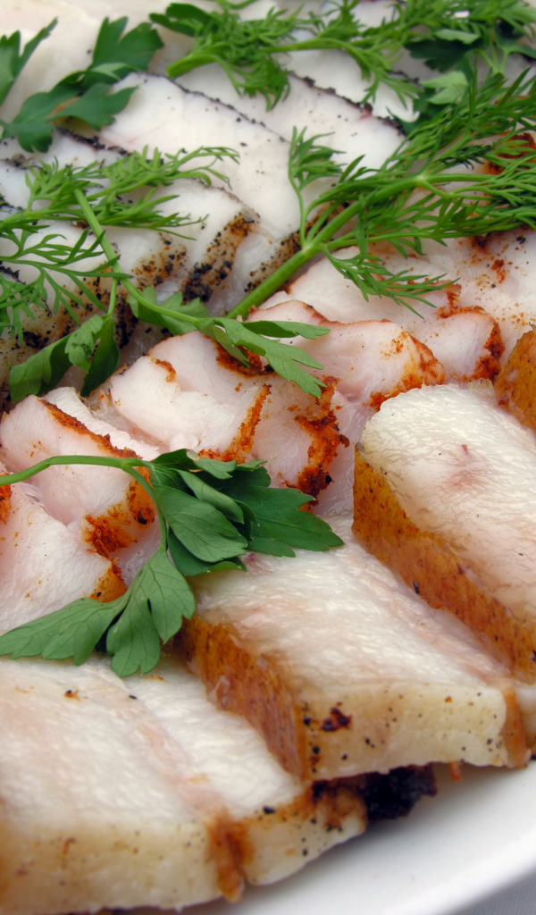 Аппетитное нарезанное копченое сало с зеленью 