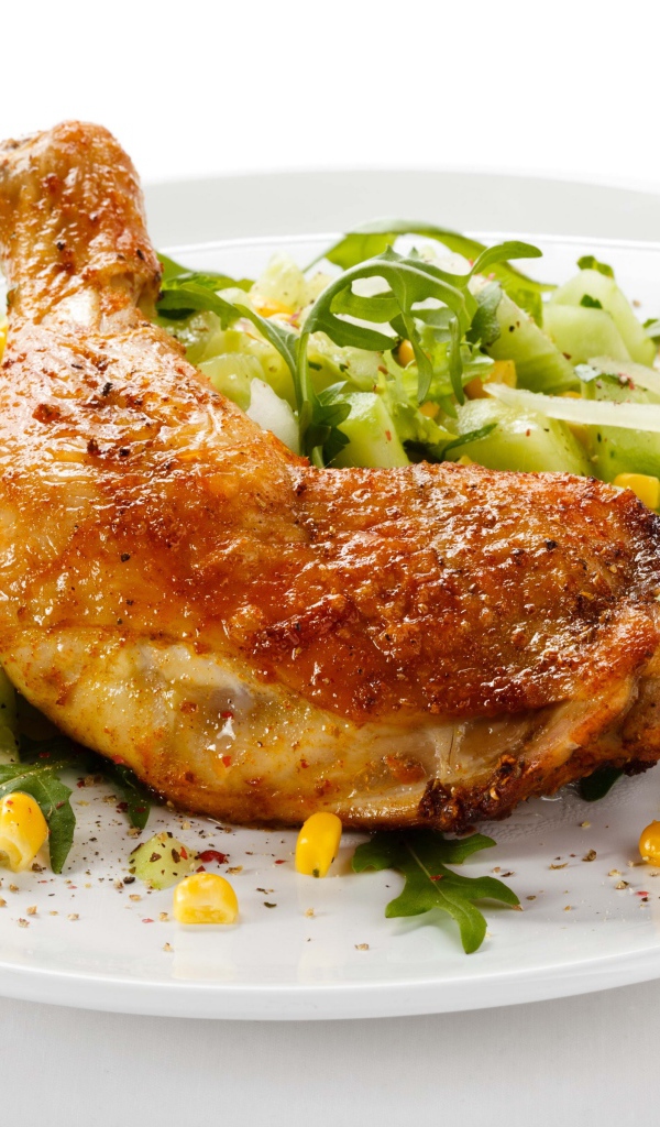 Куриный окорочок с салатом на белом фоне