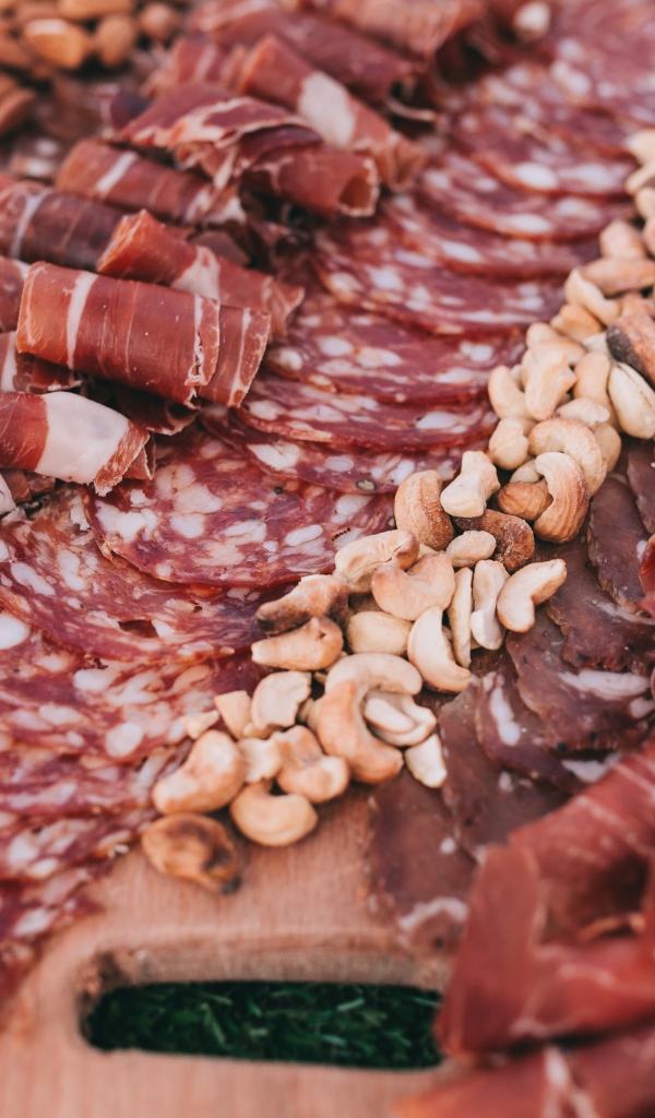 Мясная нарезка с орехами на разделочной доске